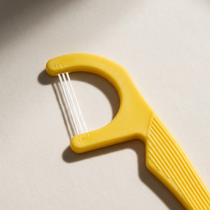 Close-up of the three strands in a yellow floss pick.