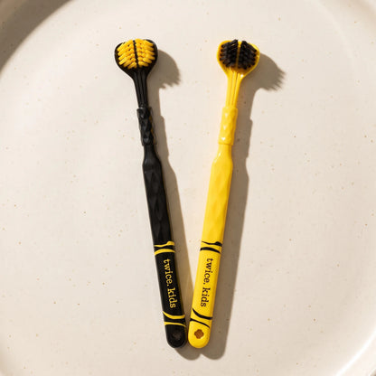 Two current Tiger-Tough Kids Triple Head toothbrushes with striped black and yellow handles